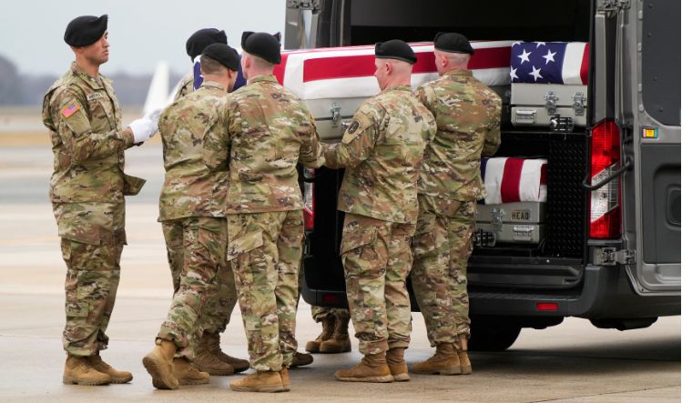 Members of the military place a casket inside a vehicle during the dignified transfer of the remains of Army Reserve Sergeants who were killed in Jordan during a drone attack 